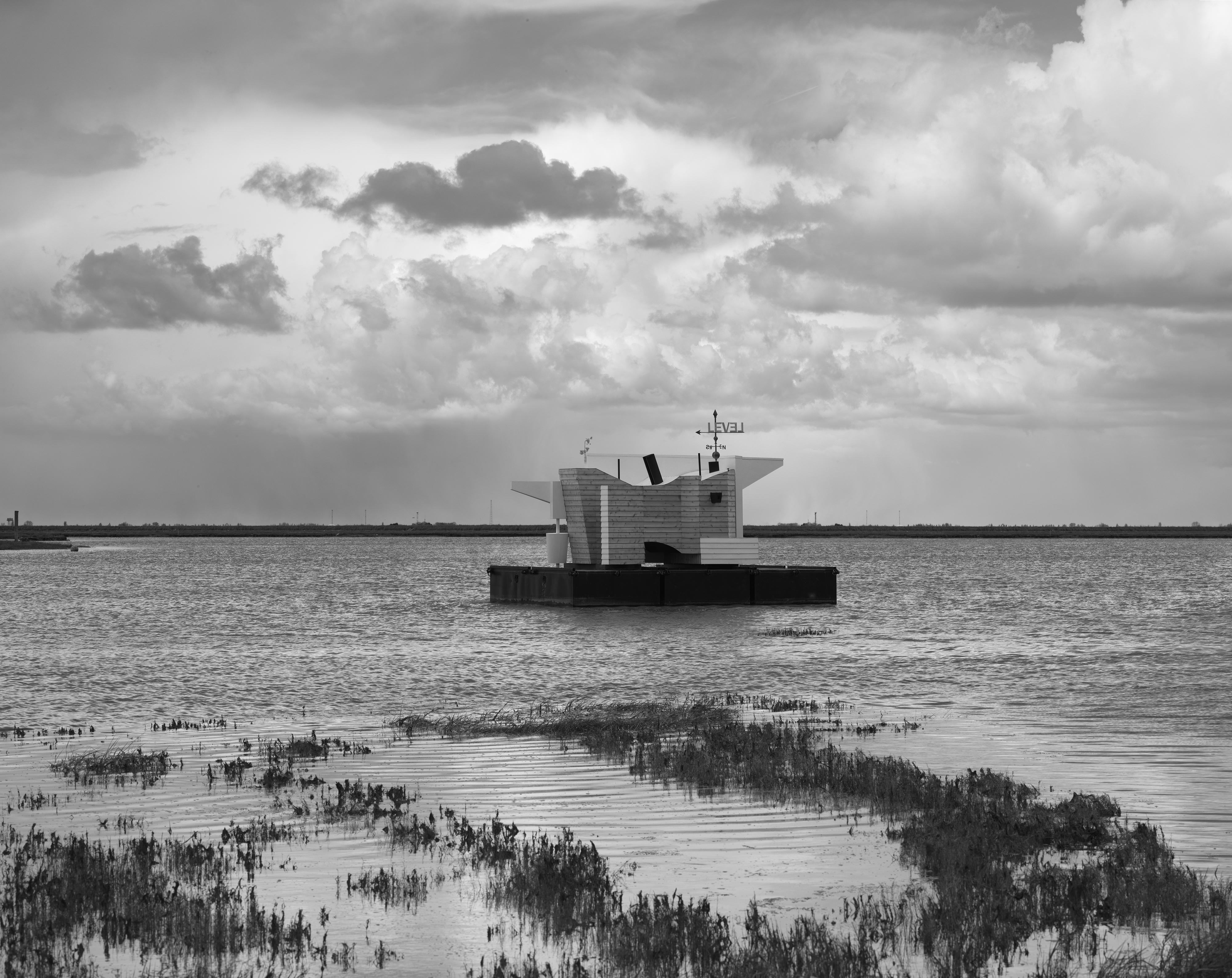 Black and white photo of Flood House on the Thames Estuary, cloudy skies